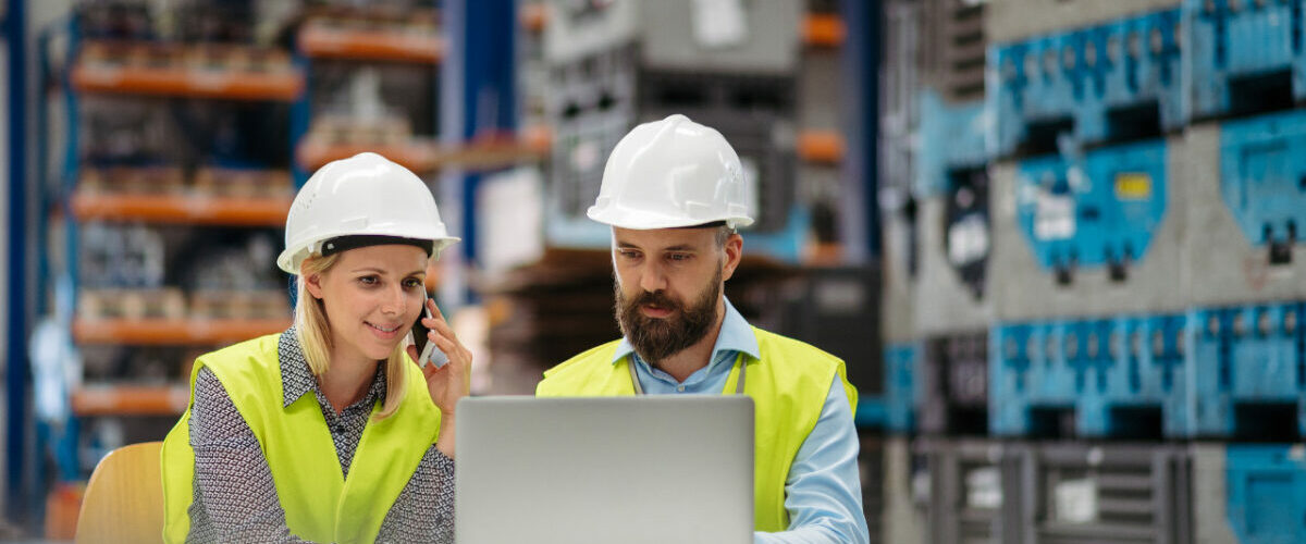 Deux ingénieurs en usine analysant des données sur ordinateur dans le cadre d’une intégration MES ERP QMS PLM